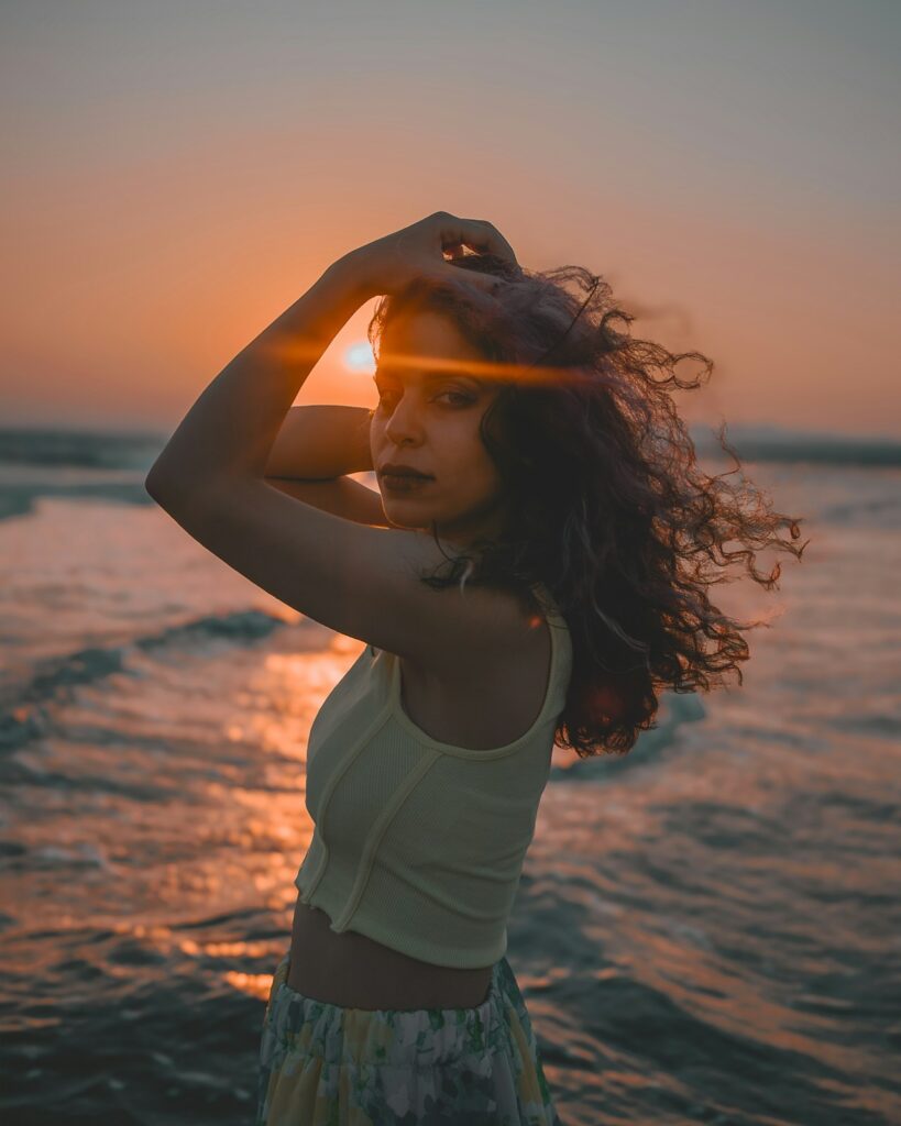a woman standing on top of a beach next to the ocean